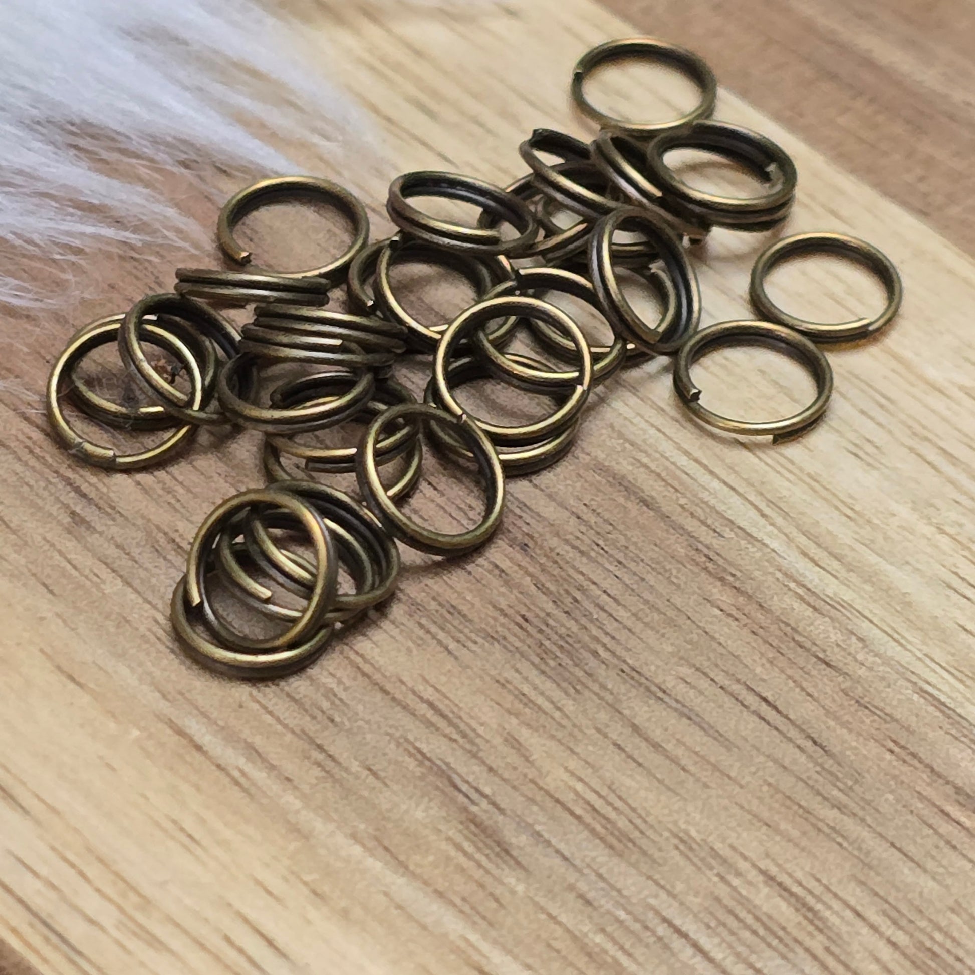 Das Bild zeigt 30 doppelte Binderinge in antik bronzefarbig mit einem Durchmesser von 7mm. Die Verbindungsringe sind ein unverzichtbares Zubehör für die Schmuckherstellung. Durch ihre doppelte Wicklung bieten sie eine besonders stabile und sichere Verbindung, sodass Anhänger, Charms und Verschlüsse zuverlässig befestigt bleiben.