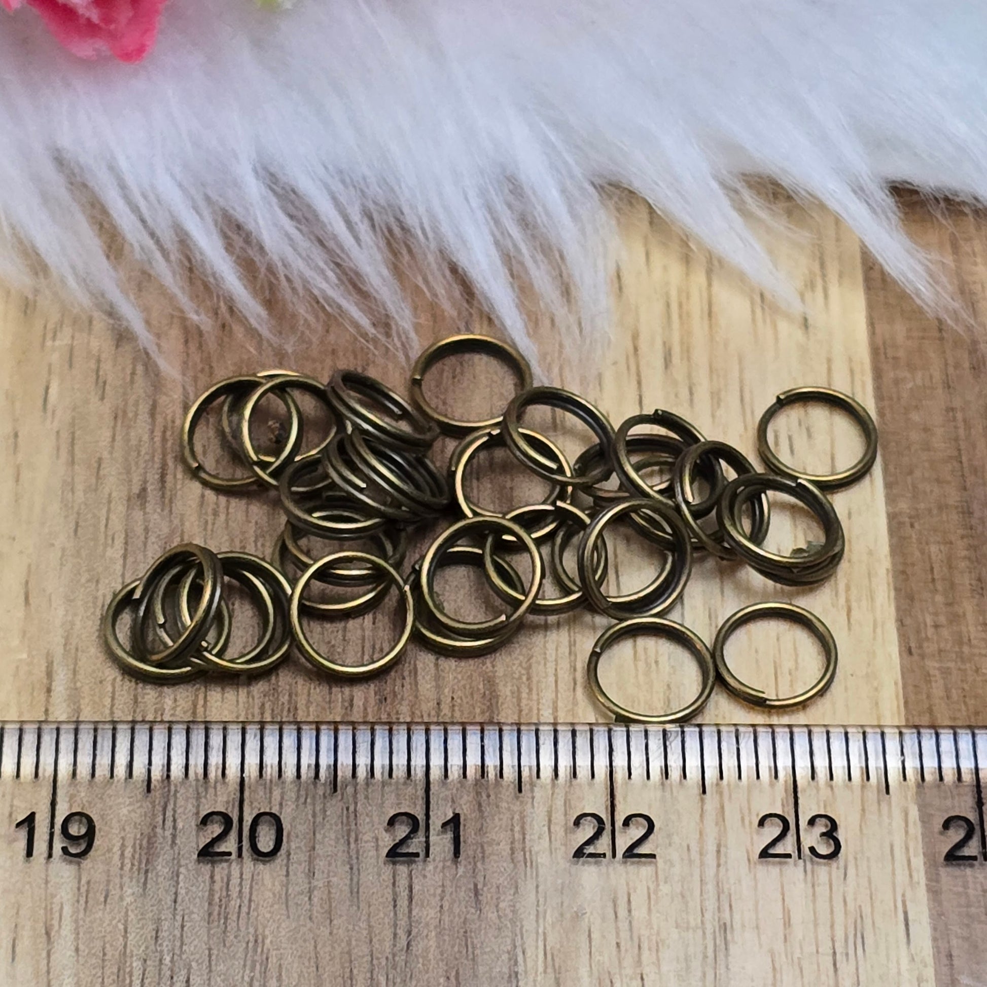 Das Bild zeigt 30 doppelte Binderinge in antik bronzefarbig mit einem Durchmesser von 7mm. Die Verbindungsringe sind ein unverzichtbares Zubehör für die Schmuckherstellung. Durch ihre doppelte Wicklung bieten sie eine besonders stabile und sichere Verbindung, sodass Anhänger, Charms und Verschlüsse zuverlässig befestigt bleiben.
