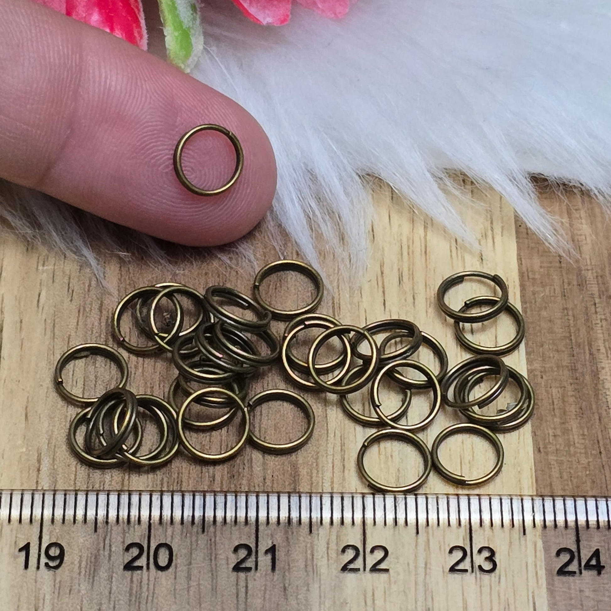Das Bild zeigt 30 doppelte Binderinge in antik bronzefarbig mit einem Durchmesser von 7mm. Die Verbindungsringe sind ein unverzichtbares Zubehör für die Schmuckherstellung. Durch ihre doppelte Wicklung bieten sie eine besonders stabile und sichere Verbindung, sodass Anhänger, Charms und Verschlüsse zuverlässig befestigt bleiben.