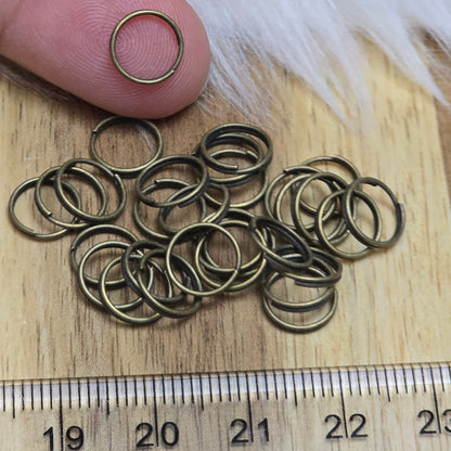 Das Bild zeigt 30 doppelte Binderinge in antik bronzefarbig mit einem Durchmesser von 8,3mm. Die Verbindungsringe sind ein unverzichtbares Zubehör für die Schmuckherstellung. Durch ihre doppelte Wicklung bieten sie eine besonders stabile und sichere Verbindung, sodass Anhänger, Charms und Verschlüsse zuverlässig befestigt bleiben.