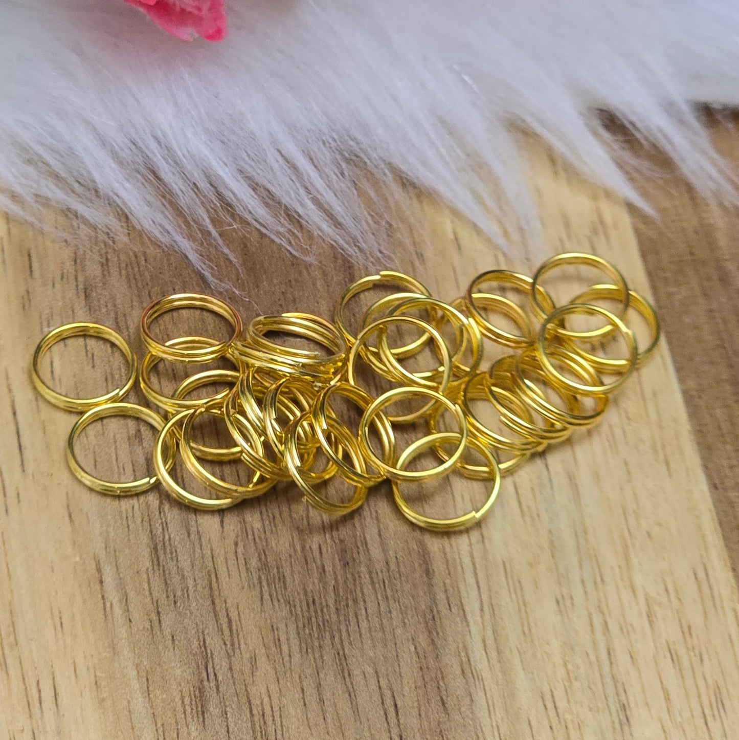 Das Bild zeigt 30 doppelte Binderinge in goldfarbig mit einem Durchmesser von  8mm. Die Verbindungsringe sind ein unverzichtbares Zubehör für die Schmuckherstellung. Durch ihre doppelte Wicklung bieten sie eine besonders stabile und sichere Verbindung, sodass Anhänger, Charms und Verschlüsse zuverlässig befestigt. 
