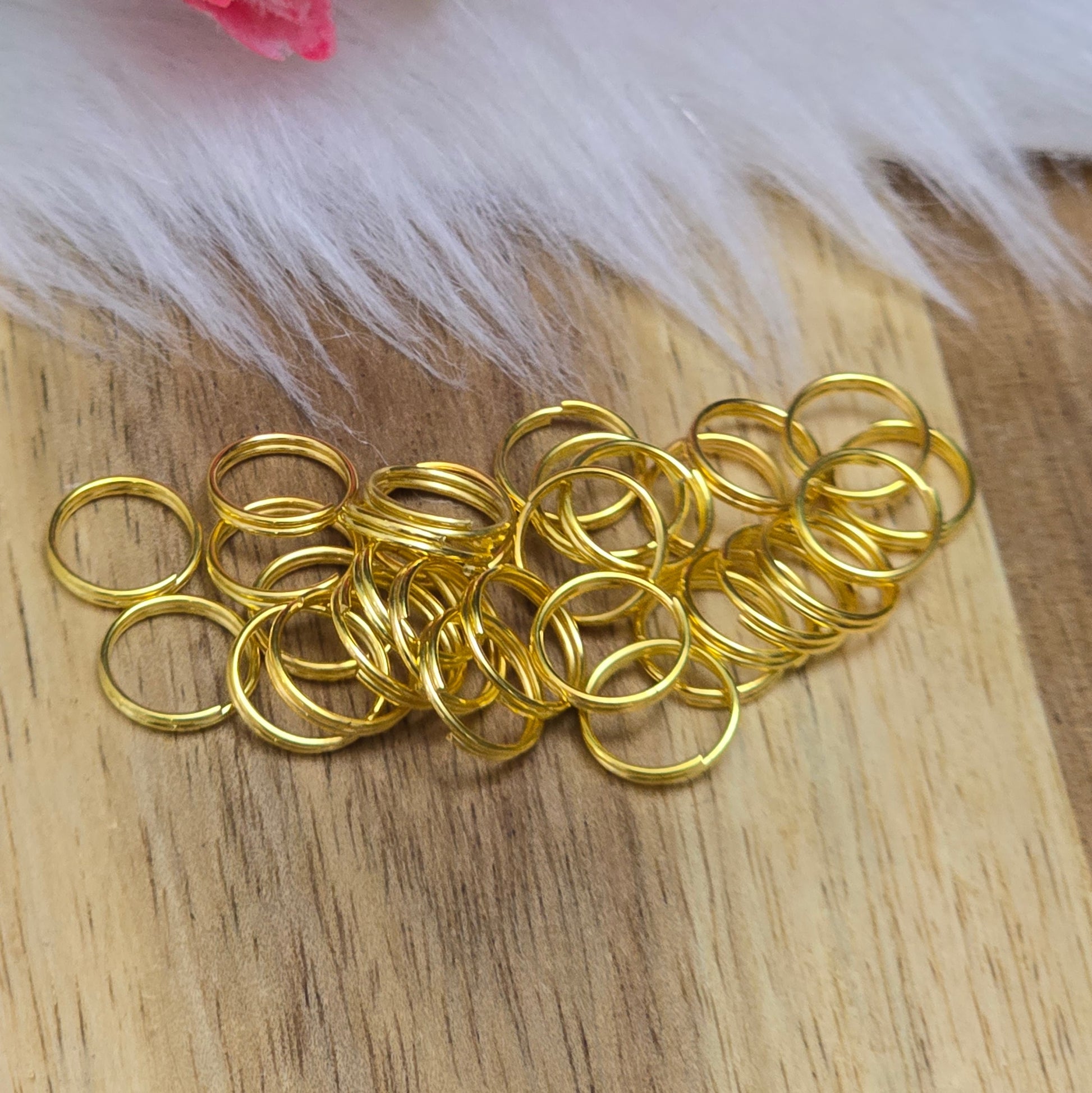 Das Bild zeigt 30 doppelte Binderinge in goldfarbig mit einem Durchmesser von  8mm. Die Verbindungsringe sind ein unverzichtbares Zubehör für die Schmuckherstellung. Durch ihre doppelte Wicklung bieten sie eine besonders stabile und sichere Verbindung, sodass Anhänger, Charms und Verschlüsse zuverlässig befestigt. 