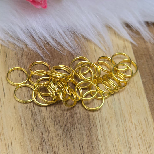 Das Bild zeigt 30 doppelte Binderinge in goldfarbig mit einem Durchmesser von  8mm. Die Verbindungsringe sind ein unverzichtbares Zubehör für die Schmuckherstellung. Durch ihre doppelte Wicklung bieten sie eine besonders stabile und sichere Verbindung, sodass Anhänger, Charms und Verschlüsse zuverlässig befestigt. 