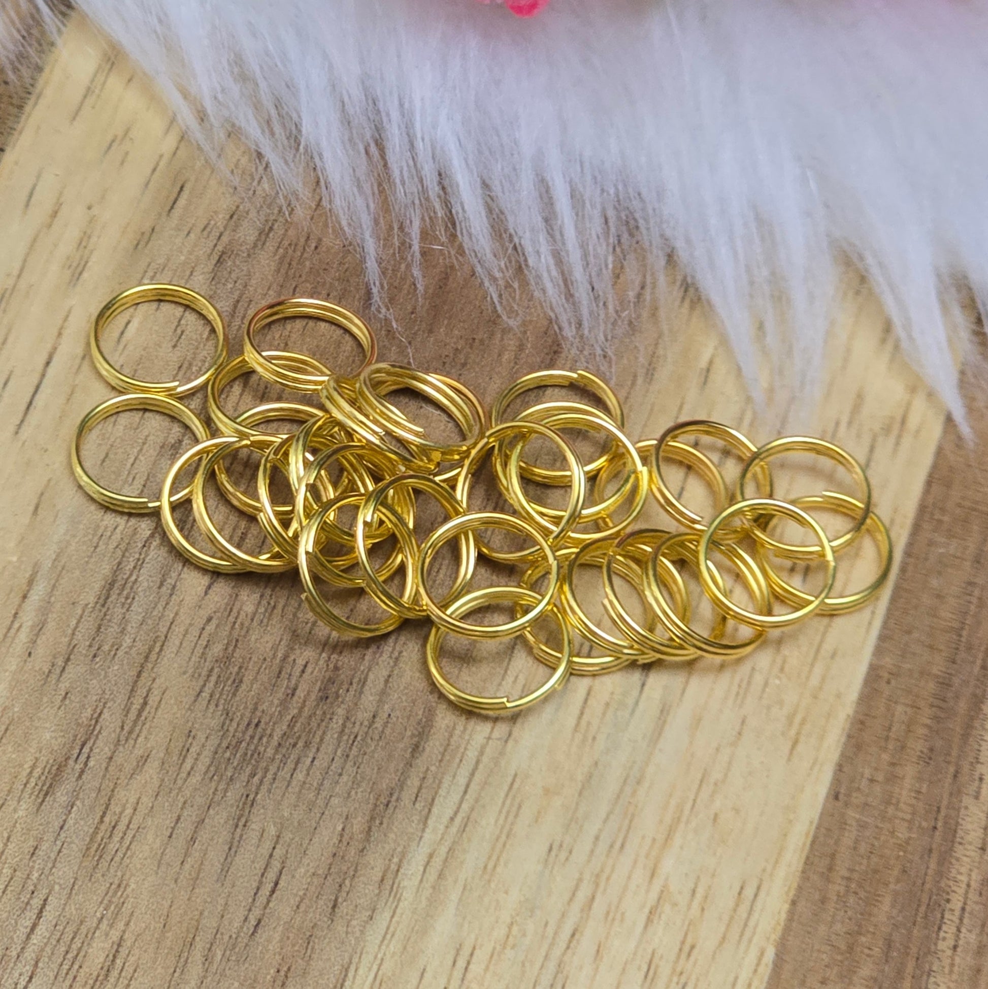 Das Bild zeigt 30 doppelte Binderinge in goldfarbig mit einem Durchmesser von  8mm. Die Verbindungsringe sind ein unverzichtbares Zubehör für die Schmuckherstellung. Durch ihre doppelte Wicklung bieten sie eine besonders stabile und sichere Verbindung, sodass Anhänger, Charms und Verschlüsse zuverlässig befestigt. 