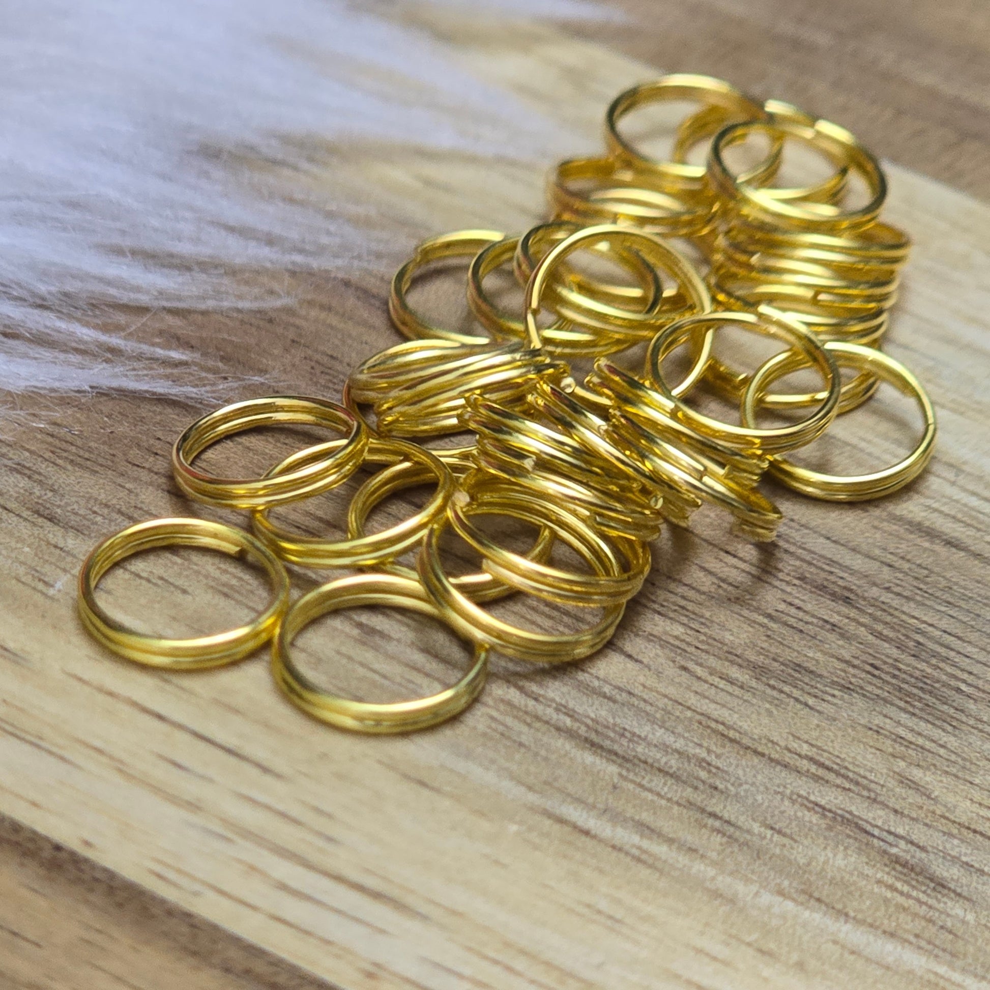 Das Bild zeigt 30 doppelte Binderinge in goldfarbig mit einem Durchmesser von  8mm. Die Verbindungsringe sind ein unverzichtbares Zubehör für die Schmuckherstellung. Durch ihre doppelte Wicklung bieten sie eine besonders stabile und sichere Verbindung, sodass Anhänger, Charms und Verschlüsse zuverlässig befestigt. 