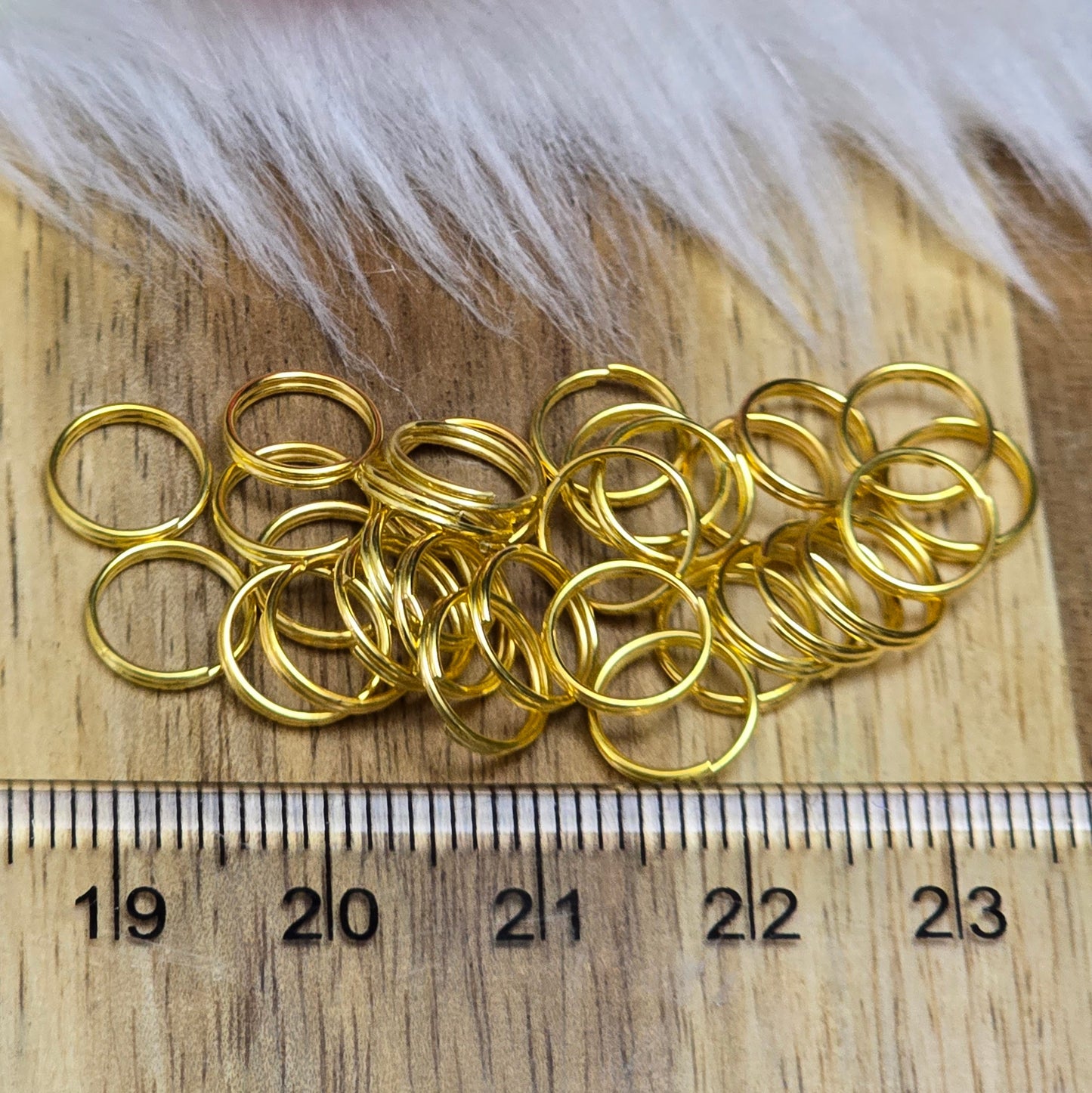 Das Bild zeigt 30 doppelte Binderinge in goldfarbig mit einem Durchmesser von  8mm. Die Verbindungsringe sind ein unverzichtbares Zubehör für die Schmuckherstellung. Durch ihre doppelte Wicklung bieten sie eine besonders stabile und sichere Verbindung, sodass Anhänger, Charms und Verschlüsse zuverlässig befestigt. 