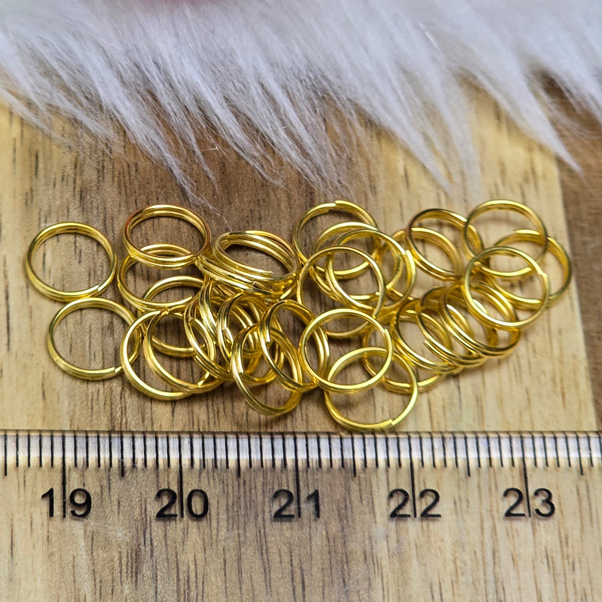 Das Bild zeigt 30 doppelte Binderinge in goldfarbig mit einem Durchmesser von  8mm. Die Verbindungsringe sind ein unverzichtbares Zubehör für die Schmuckherstellung. Durch ihre doppelte Wicklung bieten sie eine besonders stabile und sichere Verbindung, sodass Anhänger, Charms und Verschlüsse zuverlässig befestigt. 