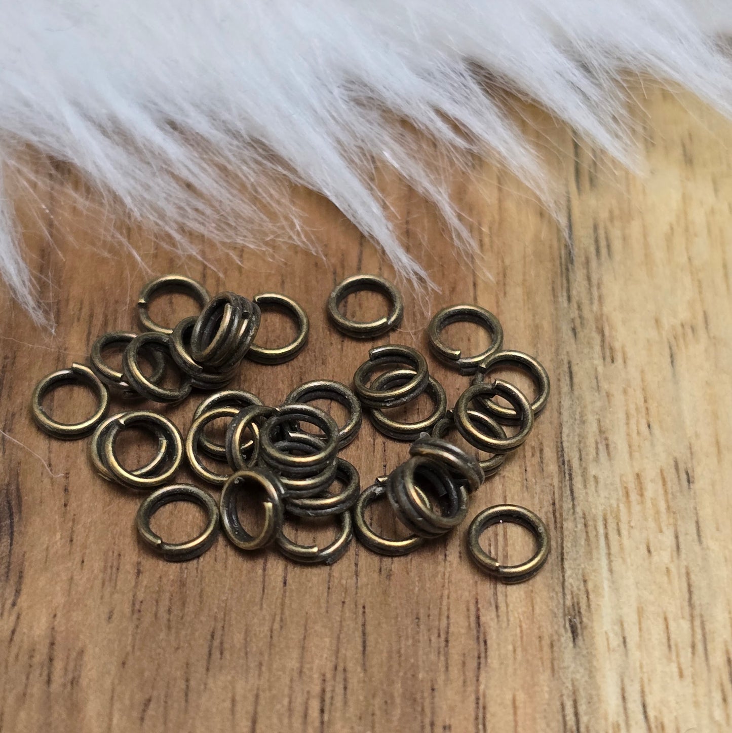 Das Bild zeigt 30 doppelte Binderinge in antikem Bronze-Finish mit 4mm im Durchmesser, ein unverzichtbares Zubehör für die Schmuckherstellung. Durch ihre doppelte Wicklung bieten sie eine besonders stabile und sichere Verbindung, sodass Anhänger, Charms und Verschlüsse zuverlässig befestigt bleiben.