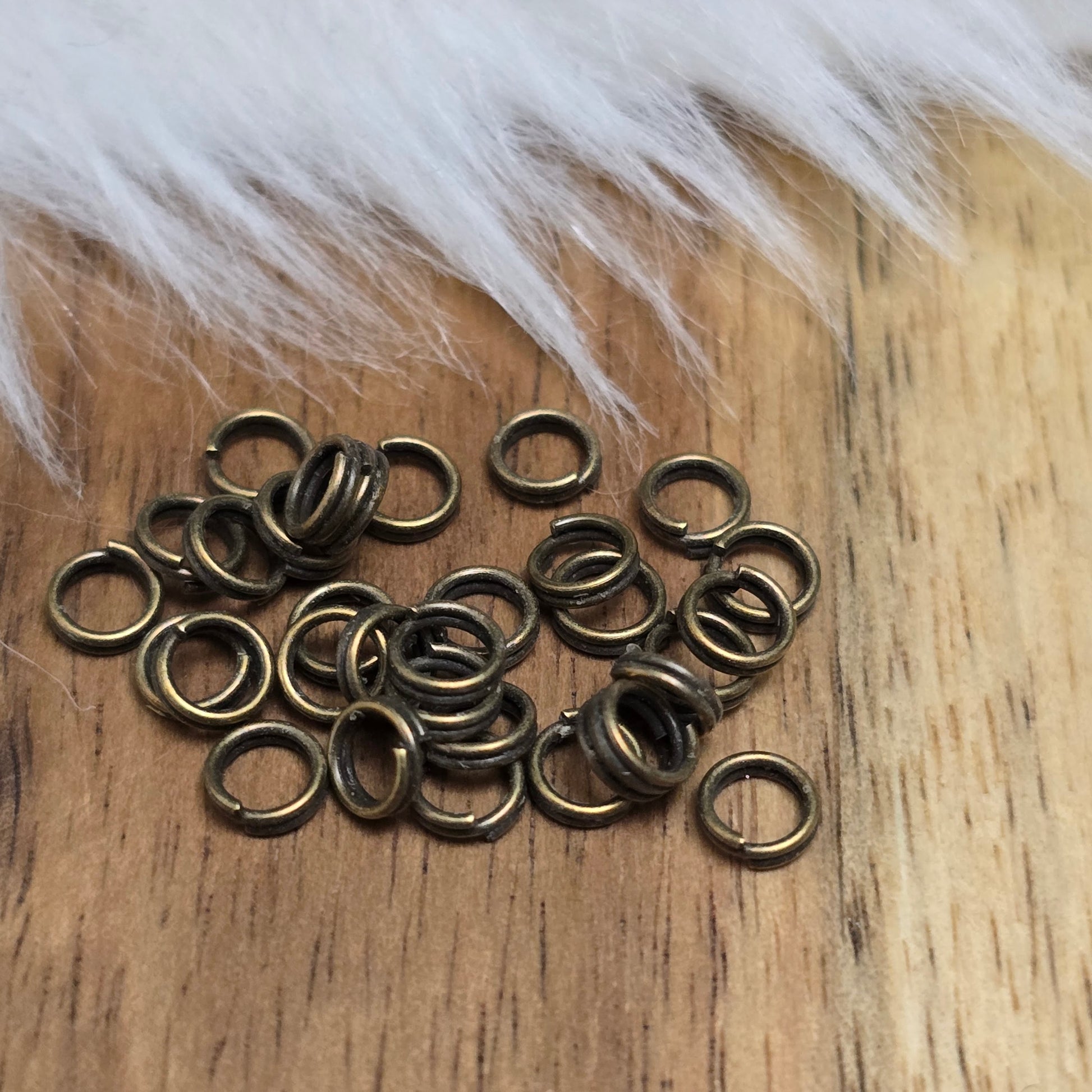 Das Bild zeigt 30 doppelte Binderinge in antikem Bronze-Finish mit 4mm im Durchmesser, ein unverzichtbares Zubehör für die Schmuckherstellung. Durch ihre doppelte Wicklung bieten sie eine besonders stabile und sichere Verbindung, sodass Anhänger, Charms und Verschlüsse zuverlässig befestigt bleiben.