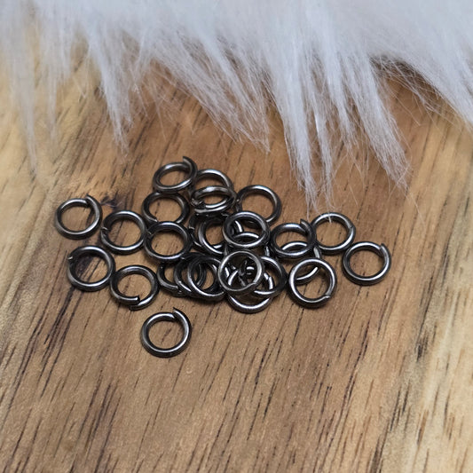Das Bild zeigt 30 offene Biegeringe in gunmetal black mit 4,2mm Durchmesser, ein unverzichtbares Zubehör für die Schmuckherstellung. Ideal um Charms und Verschlüsse zuverlässig zu befestigen.
