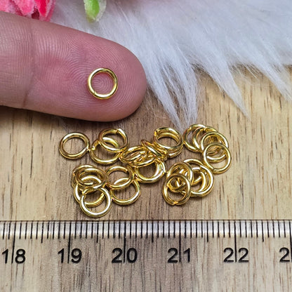 Das Bild zeigt 30 offene Biegeringe in vergoldet mit einem Durchmesser von 6mm. Die Verbindungsringe sind ein unverzichtbares Zubehör für die Schmuckherstellung. Ideal um Charms und Verschlüsse zuverlässig zu befestigen.