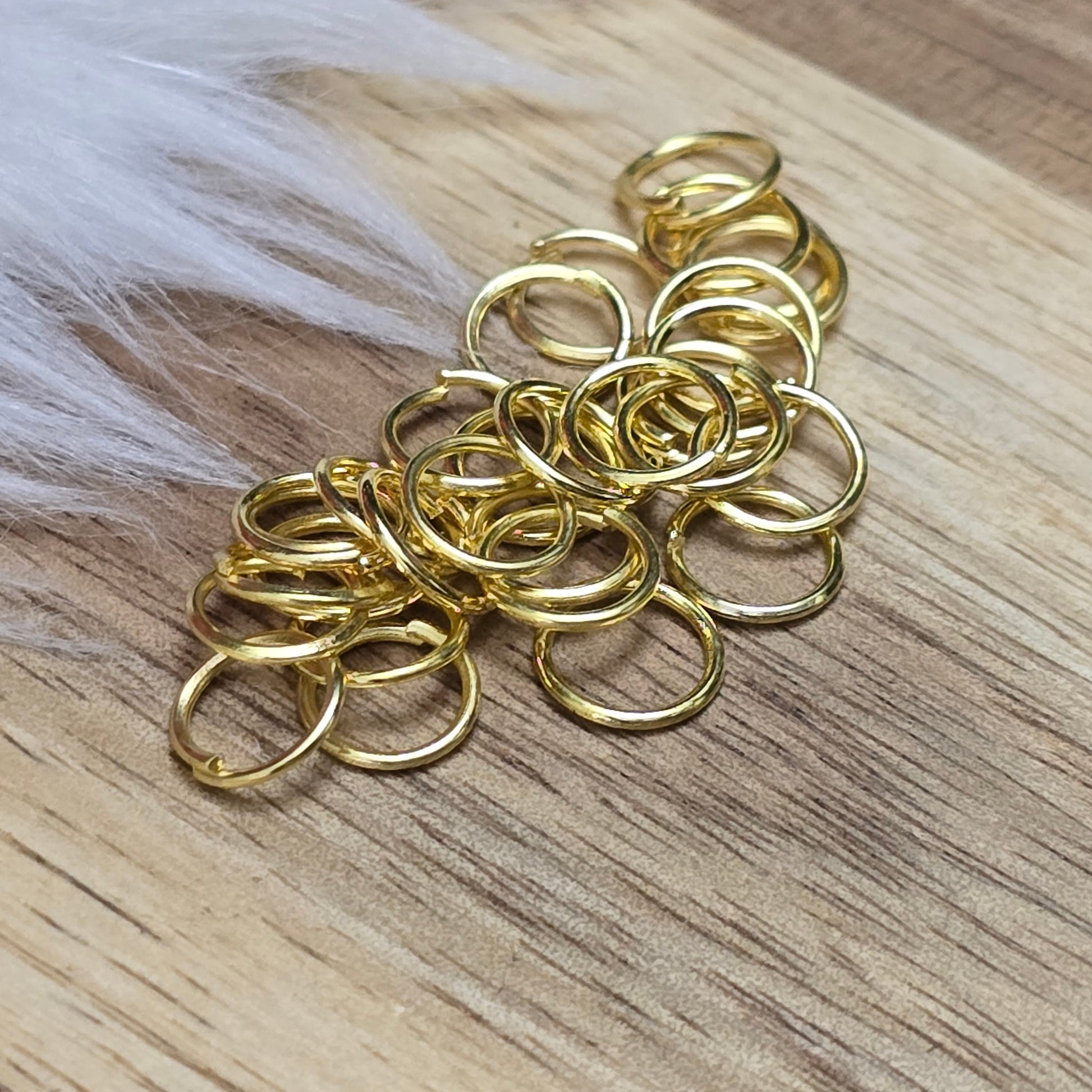Das Bild zeigt 30 offene Biegeringe in vergoldet mit einem Durchmesser von 7mm. Die Verbindungsringe sind ein unverzichtbares Zubehör für die Schmuckherstellung. Ideal um Charms und Verschlüsse zuverlässig zu befestigen.