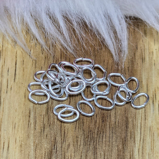 Das Bild zeigt 30 ovale, offenen Biegeringe in versilbert mit der Abmessung 5,4 x 4mm. Diese Verbindungsringe sind ein unverzichtbares Zubehör für die Schmuckherstellung. Ideal um Charms und Verschlüsse zuverlässig zu befestigen.