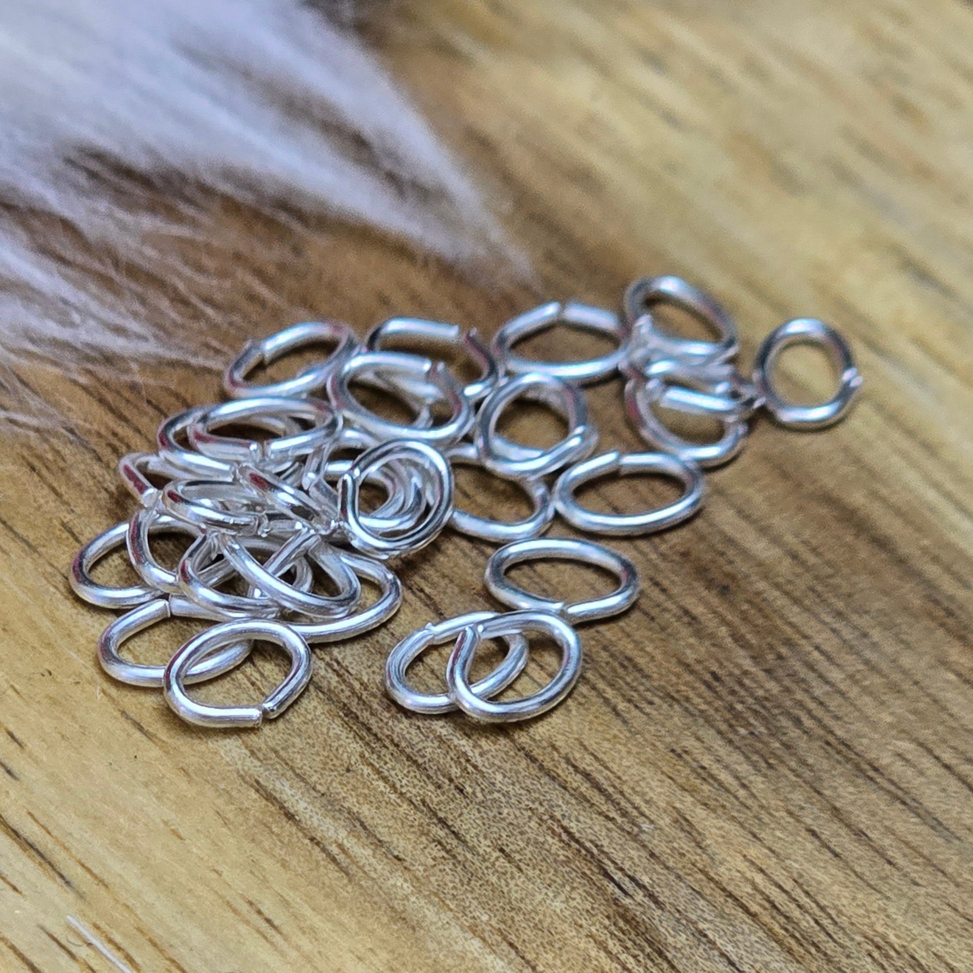 Das Bild zeigt 30 ovale, offenen Biegeringe in versilbert mit der Abmessung 5,4 x 4mm. Diese Verbindungsringe sind ein unverzichtbares Zubehör für die Schmuckherstellung. Ideal um Charms und Verschlüsse zuverlässig zu befestigen.