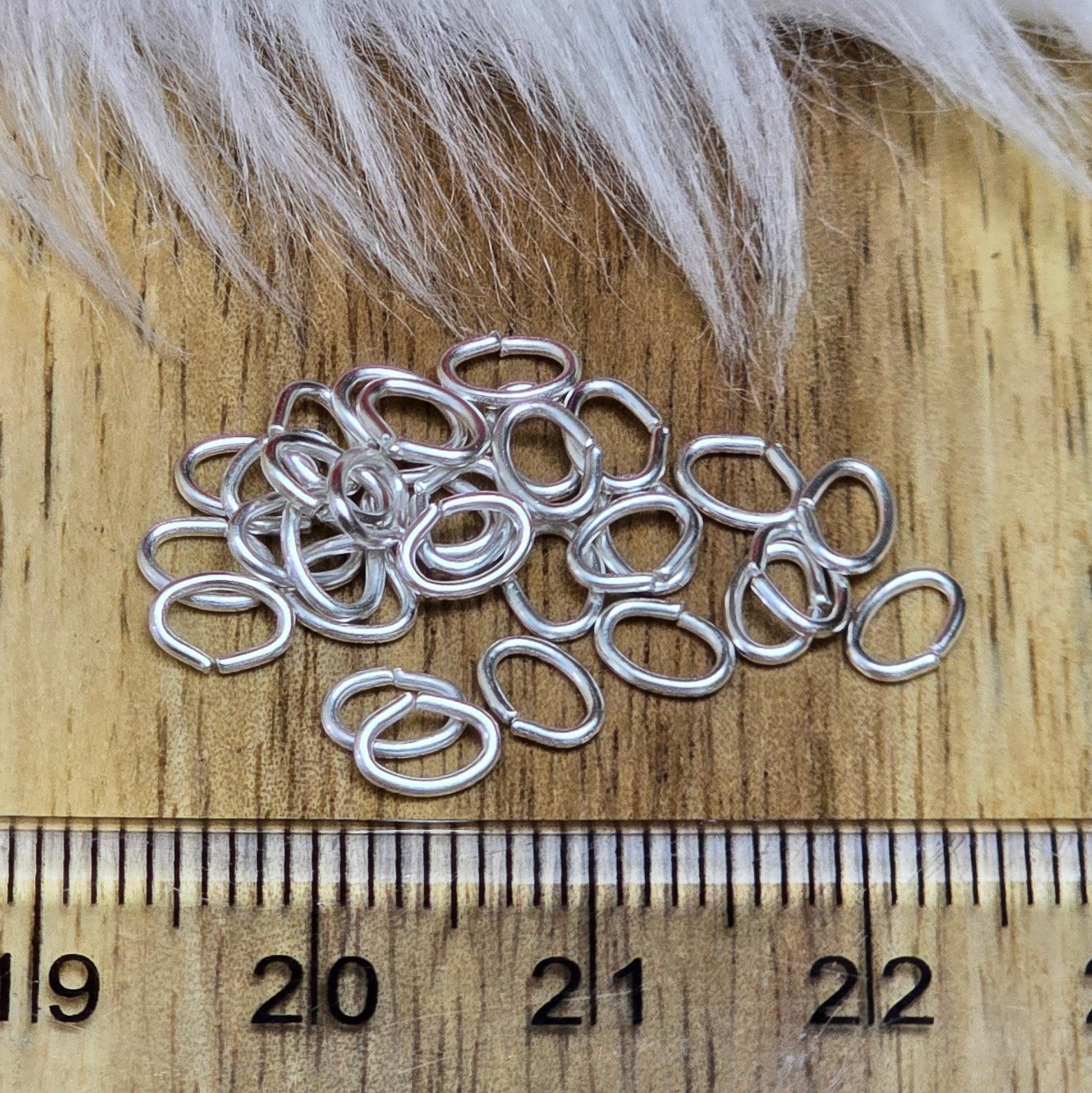 Das Bild zeigt 30 ovale, offenen Biegeringe in versilbert mit der Abmessung 5,4 x 4mm. Diese Verbindungsringe sind ein unverzichtbares Zubehör für die Schmuckherstellung. Ideal um Charms und Verschlüsse zuverlässig zu befestigen.