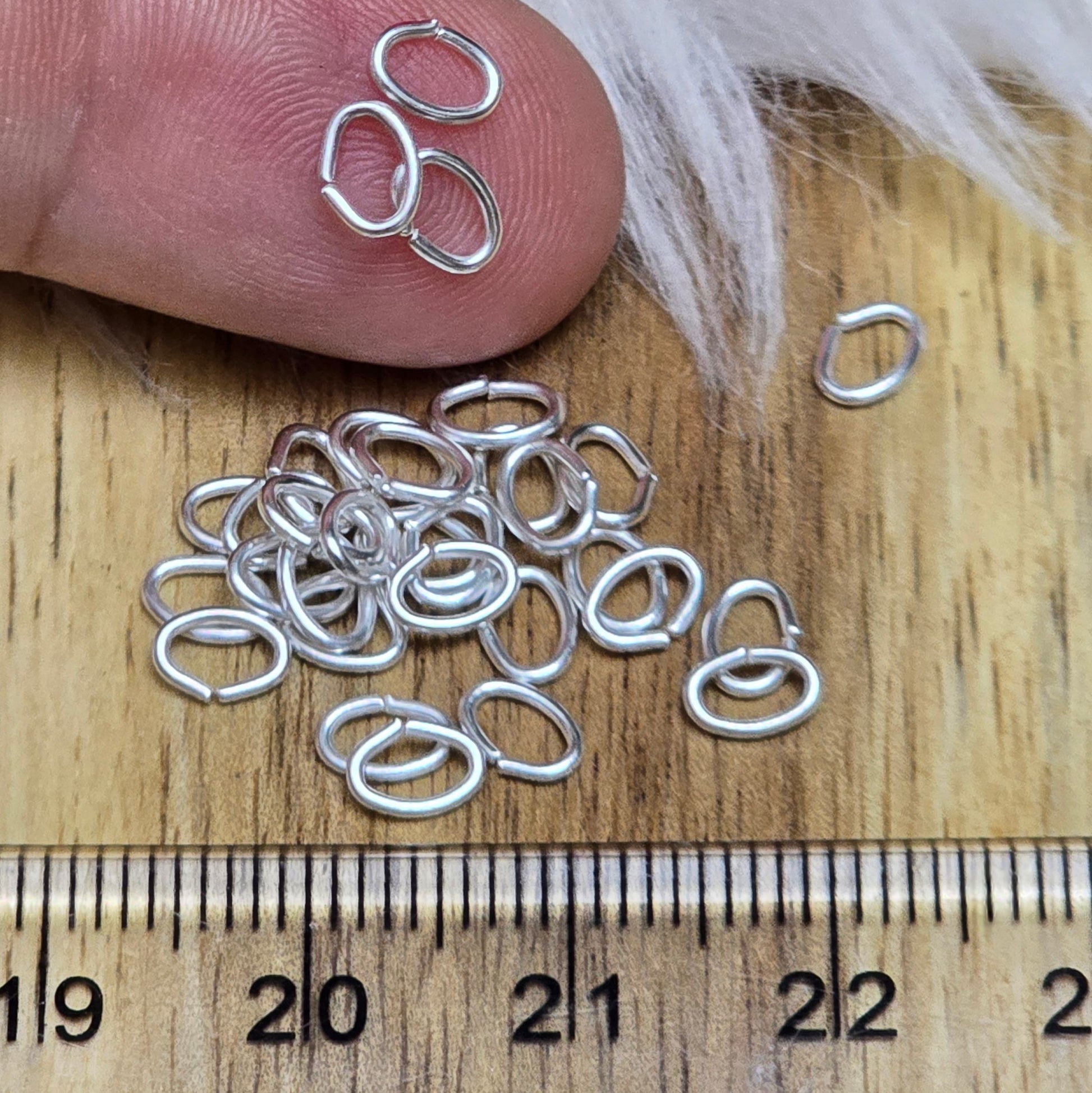 Das Bild zeigt 30 ovale, offenen Biegeringe in versilbert mit der Abmessung 5,4 x 4mm. Diese Verbindungsringe sind ein unverzichtbares Zubehör für die Schmuckherstellung. Ideal um Charms und Verschlüsse zuverlässig zu befestigen.