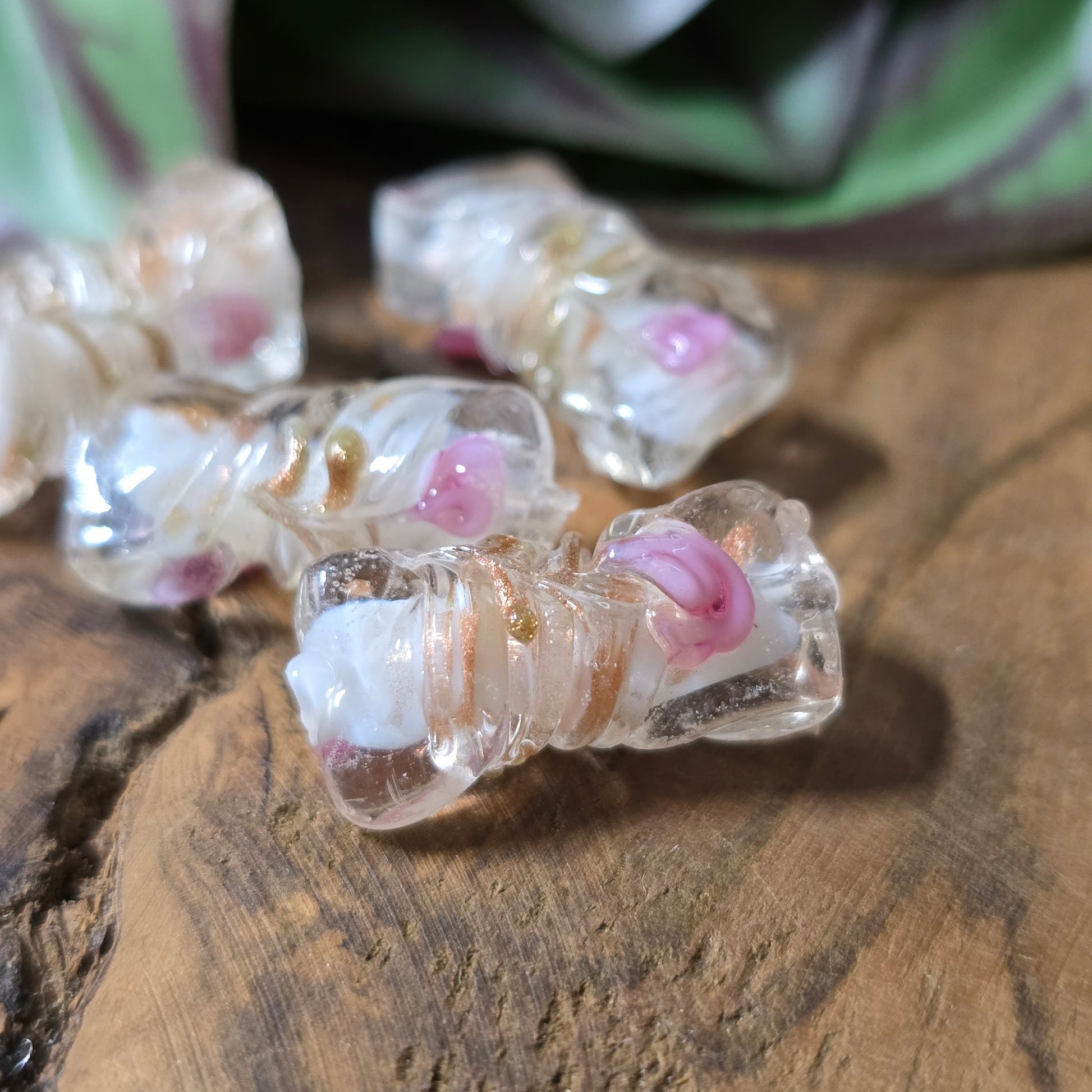 4 handgefertigte Glasperlen in gedrehter Walzenform (21mm), klar mit weißem Kern, Röschen & Glitzer – perfekt für romantischen DIY-Schmuck.