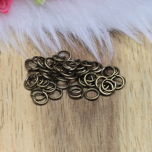 Das Bild zeigt 50 offene Biegeringe in antik bronzefarbig mit einem Durchmesser von 5mm. Die Verbindungsringe sind ein unverzichtbares Zubehör für die Schmuckherstellung. Ideal um Charms und Verschlüsse zuverlässig zu befestigen.