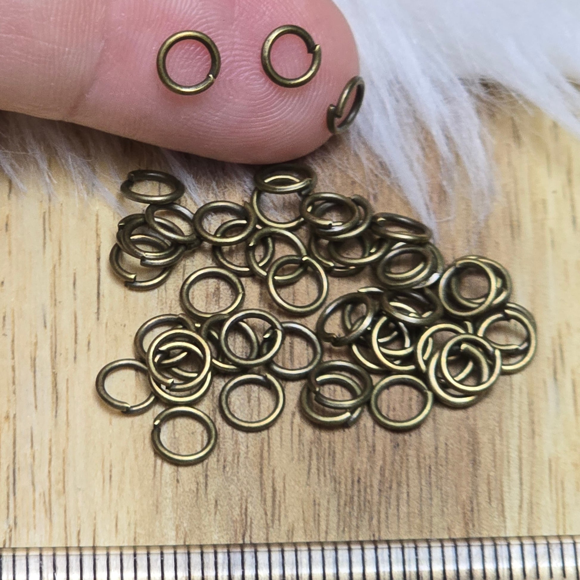 Das Bild zeigt 50 offene Biegeringe in antik bronzefarbig mit einem Durchmesser von 5mm. Die Verbindungsringe sind ein unverzichtbares Zubehör für die Schmuckherstellung. Ideal um Charms und Verschlüsse zuverlässig zu befestigen.