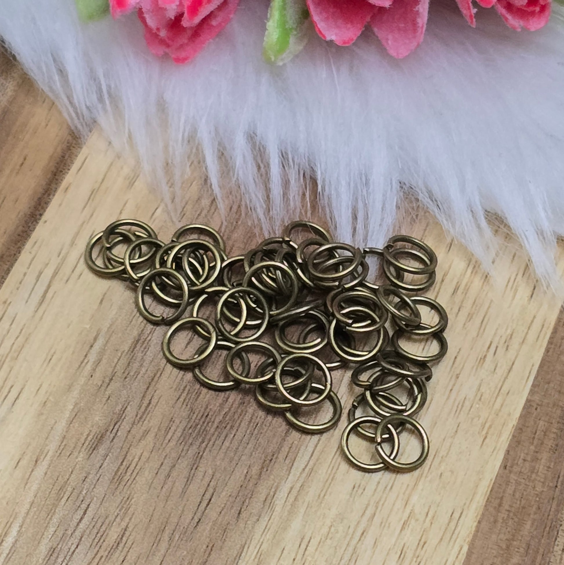 Das Bild zeigt 50 offene Biegeringe in antik bronzefarbig mit einem Durchmesser von  sind ein unverzichtbares Zubehör für die Schmuckherstellung. Ideal um Charms und Verschlüsse zuverlässig zu befestigen.,5mm. Die Verbindungsringe 