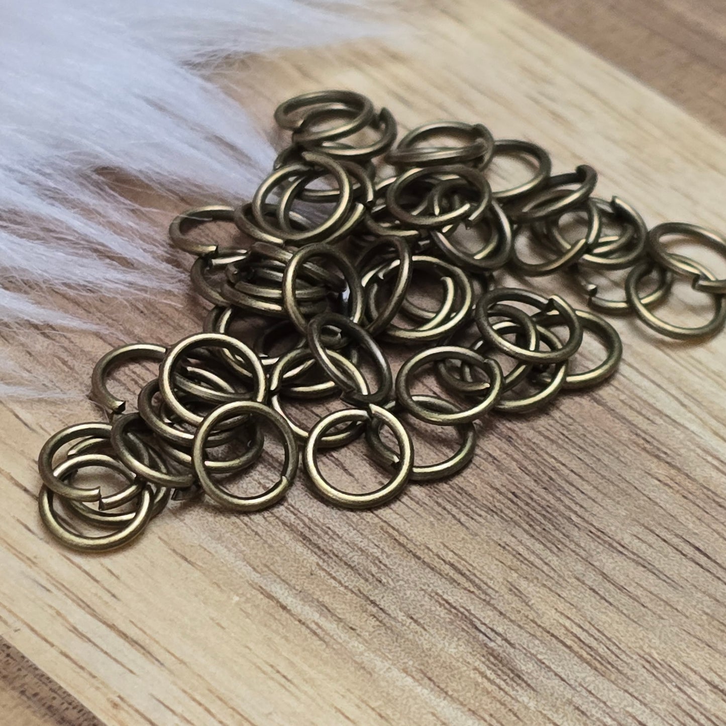 Das Bild zeigt 50 offene Biegeringe in antik bronzefarbig mit einem Durchmesser von  sind ein unverzichtbares Zubehör für die Schmuckherstellung. Ideal um Charms und Verschlüsse zuverlässig zu befestigen.,5mm. Die Verbindungsringe 