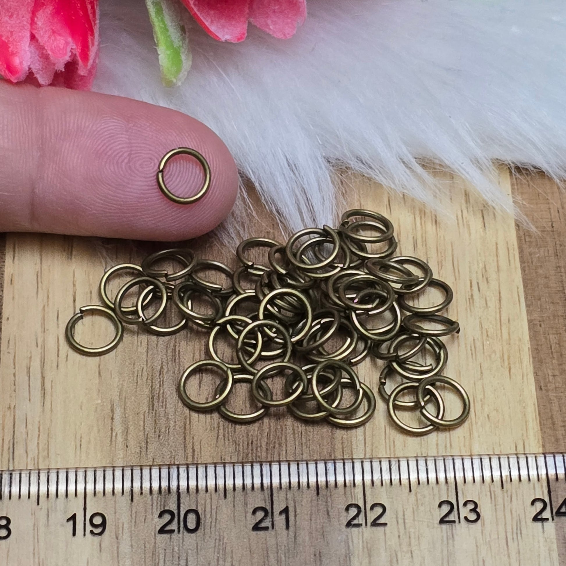 Das Bild zeigt 50 offene Biegeringe in antik bronzefarbig mit einem Durchmesser von  sind ein unverzichtbares Zubehör für die Schmuckherstellung. Ideal um Charms und Verschlüsse zuverlässig zu befestigen.,5mm. Die Verbindungsringe 