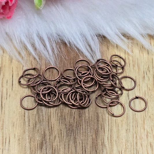Das Bild zeigt 50 offene Biegeringe in antik kupferfarbig mit einem Durchmesser von 6mm. Die Verbindungsringe sind ein unverzichtbares Zubehör für die Schmuckherstellung. Ideal um Charms und Verschlüsse zuverlässig zu befestigen.