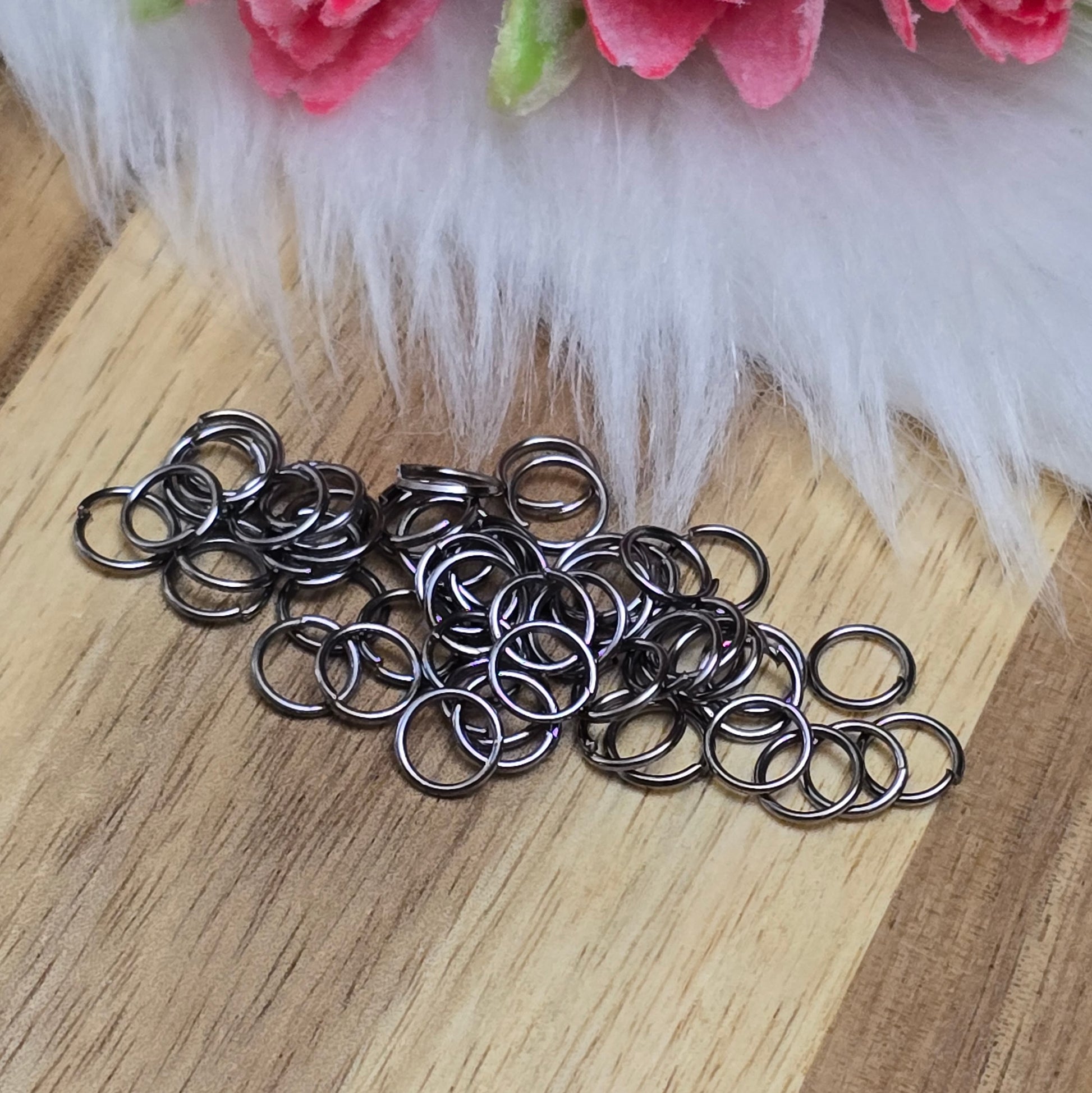 Das Bild zeigt 50 offene Biegeringe in gunmetal black mit einem Durchmesser von 6mm. Die Verbindungsringe sind ein unverzichtbares Zubehör für die Schmuckherstellung. Ideal um Charms und Verschlüsse zuverlässig zu befestigen.