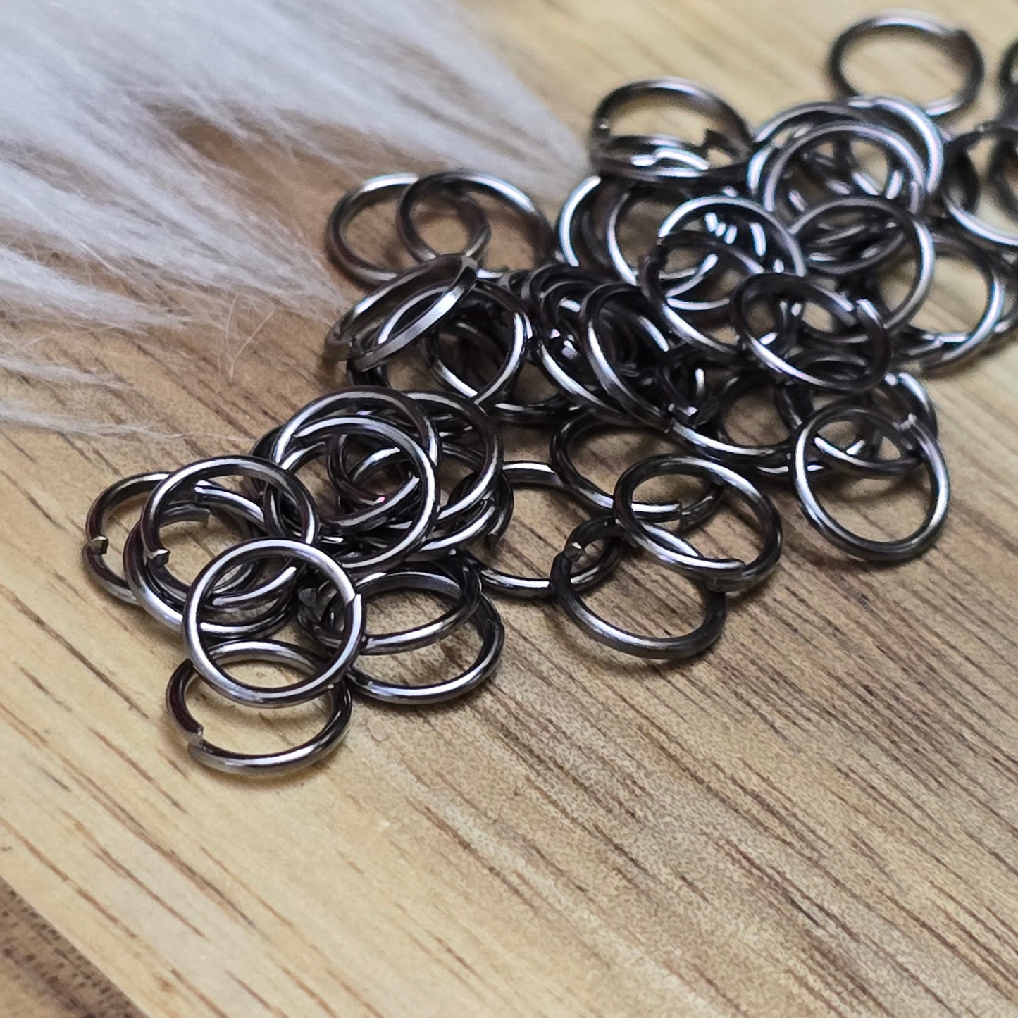 Das Bild zeigt 50 offene Biegeringe in gunmetal black mit einem Durchmesser von 6mm. Die Verbindungsringe sind ein unverzichtbares Zubehör für die Schmuckherstellung. Ideal um Charms und Verschlüsse zuverlässig zu befestigen.