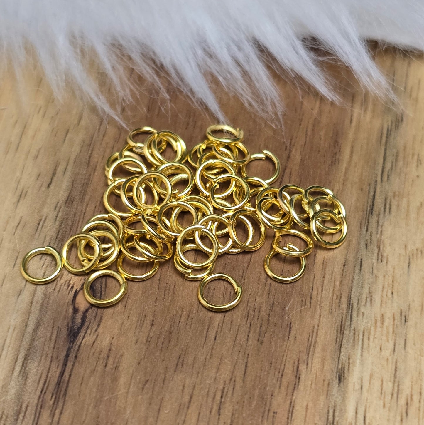 Das Bild zeigt 50 offene Biegeringe in vergoldet mit einem Durchmesser von 5mm, ein unverzichtbares Zubehör für die Schmuckherstellung. Ideal um Charms und Verschlüsse zuverlässig zu befestigen.