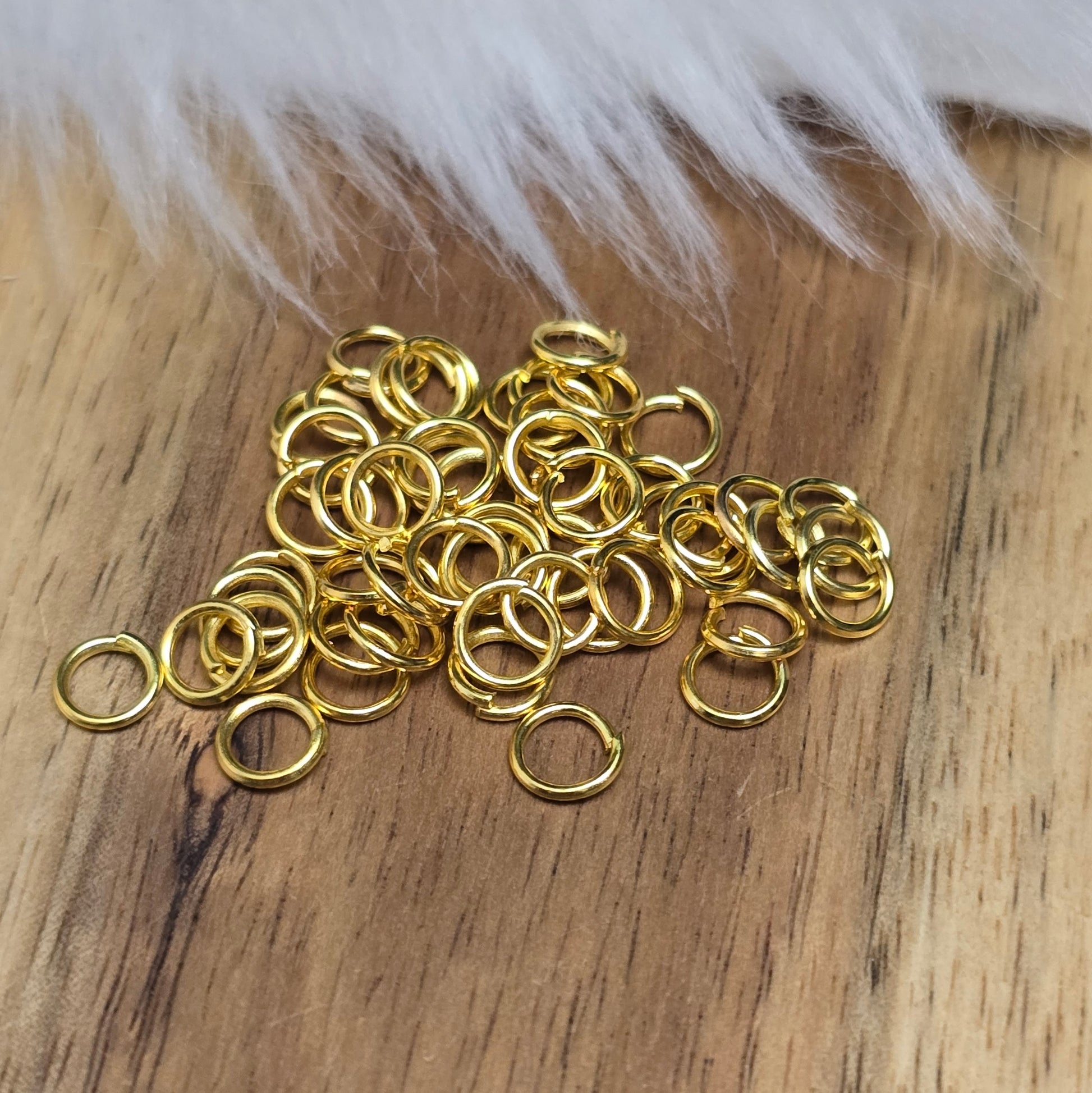 Das Bild zeigt 50 offene Biegeringe in vergoldet mit einem Durchmesser von 5mm, ein unverzichtbares Zubehör für die Schmuckherstellung. Ideal um Charms und Verschlüsse zuverlässig zu befestigen.