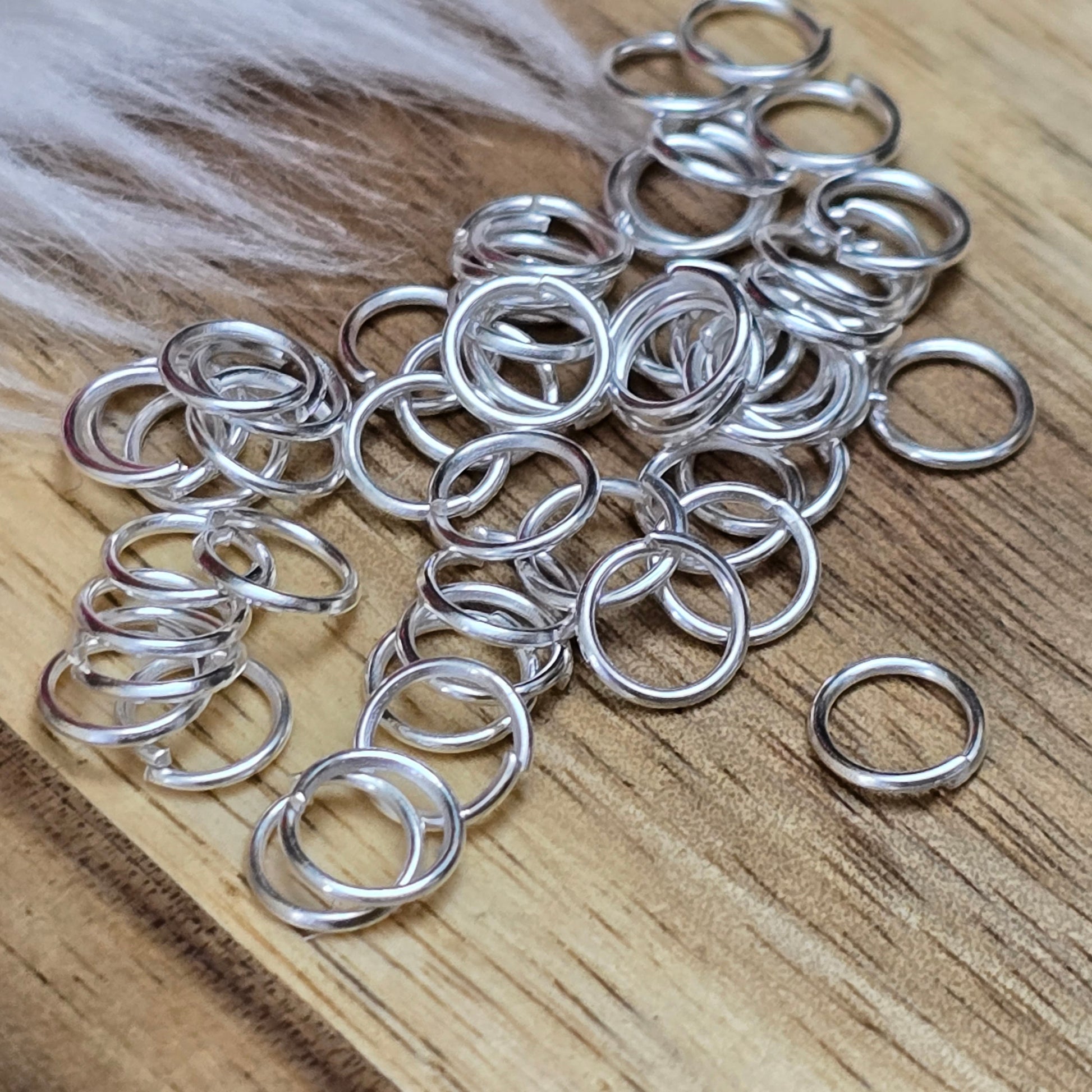 Das Bild zeigt 50 offene Biegeringe in versilbert mit einem Durchmesser von 6mm. Die Verbindungsringe sind ein unverzichtbares Zubehör für die Schmuckherstellung. Ideal um Charms und Verschlüsse zuverlässig zu befestigen.