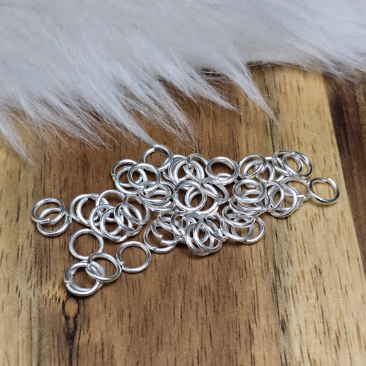 Das Bild zeigt 50 offene Biegeringe in versilbert mit einem Durchmesser von 5mm, ein unverzichtbares Zubehör für die Schmuckherstellung. Ideal um Charms und Verschlüsse zuverlässig zu befestigen.