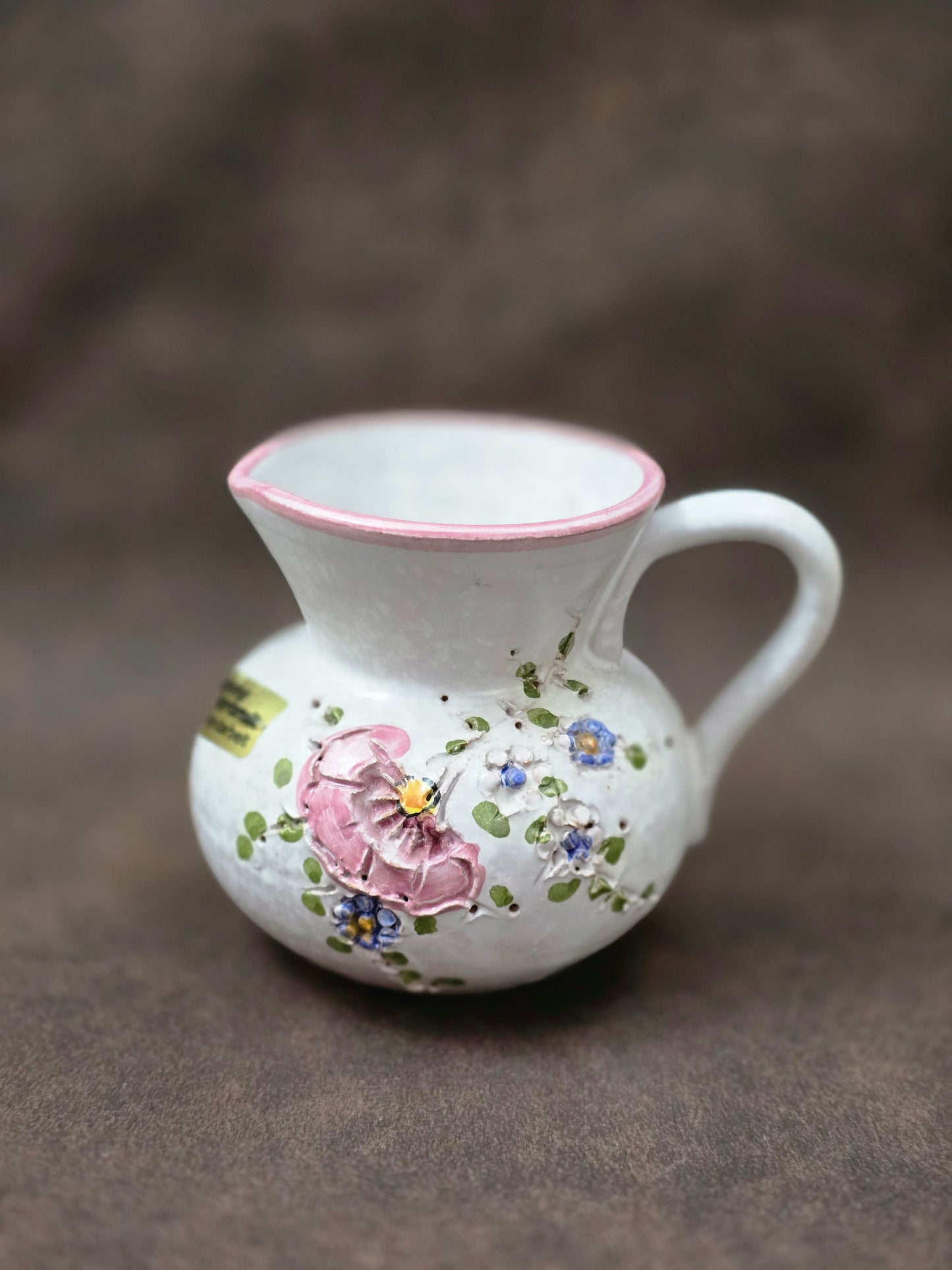 Handgefertigter Vintage-Dekokrug aus Ainring Keramik mit floralem Relief, matter Glasur und Originalaufkleber, deutsche Kunstkeramik der 1960er–1970er Jahre.