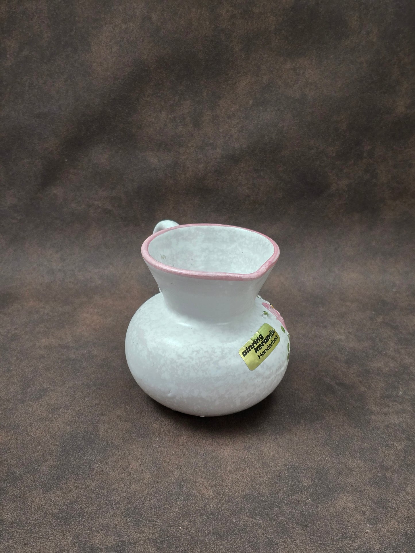 Handgefertigter Vintage-Dekokrug aus Ainring Keramik mit floralem Relief, matter Glasur und Originalaufkleber, deutsche Kunstkeramik der 1960er–1970er Jahre.