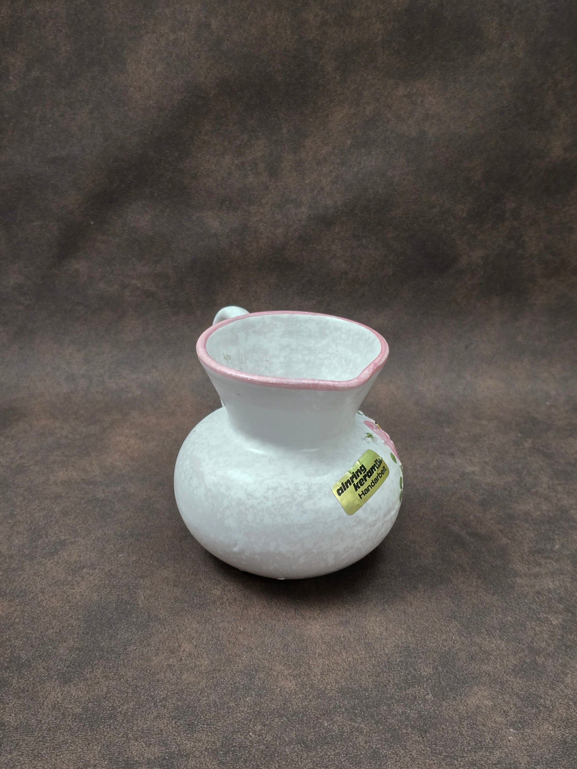 Handgefertigter Vintage-Dekokrug aus Ainring Keramik mit floralem Relief, matter Glasur und Originalaufkleber, deutsche Kunstkeramik der 1960er–1970er Jahre.