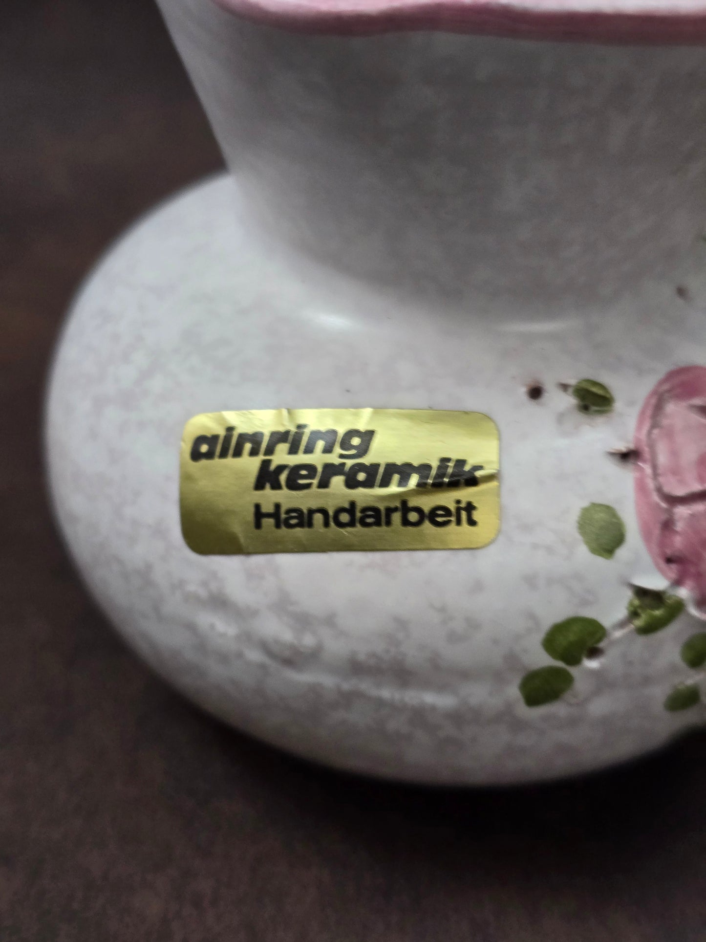 Handgefertigter Vintage-Dekokrug aus Ainring Keramik mit floralem Relief, matter Glasur und Originalaufkleber, deutsche Kunstkeramik der 1960er–1970er Jahre.