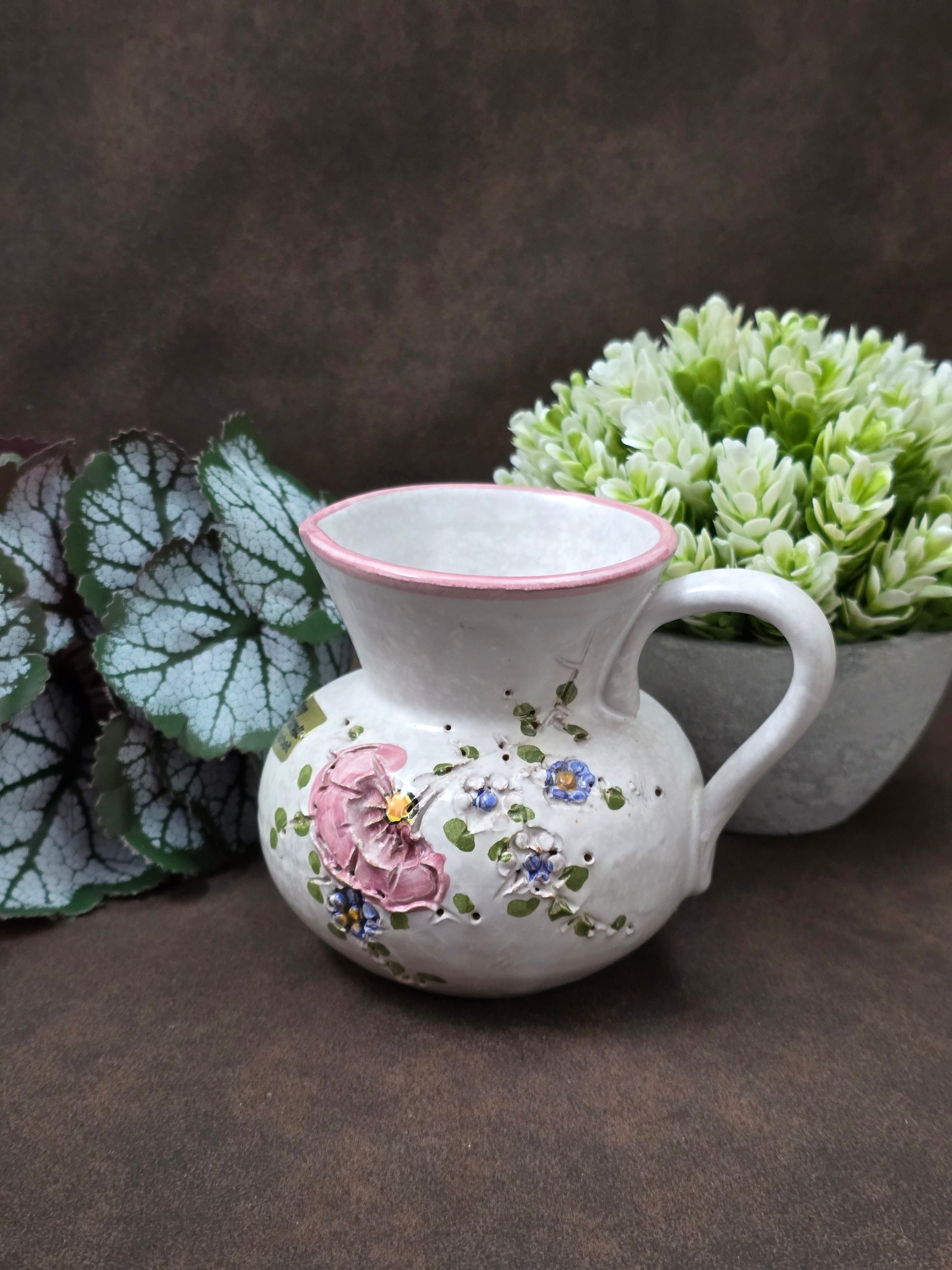 Handgefertigter Vintage-Dekokrug aus Ainring Keramik mit floralem Relief, matter Glasur und Originalaufkleber, deutsche Kunstkeramik der 1960er–1970er Jahre.