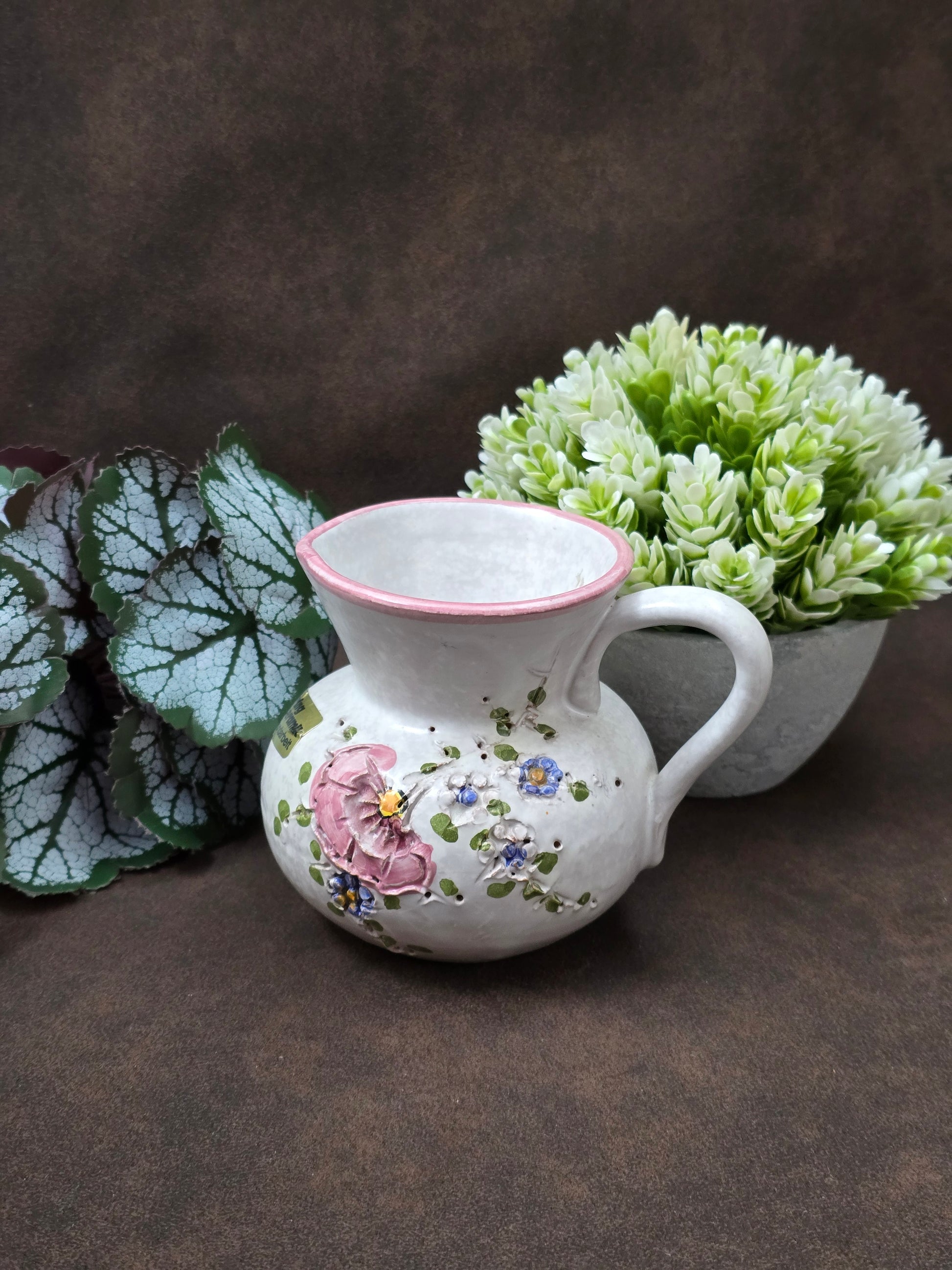 Handgefertigter Vintage-Dekokrug aus Ainring Keramik mit floralem Relief, matter Glasur und Originalaufkleber, deutsche Kunstkeramik der 1960er–1970er Jahre.
