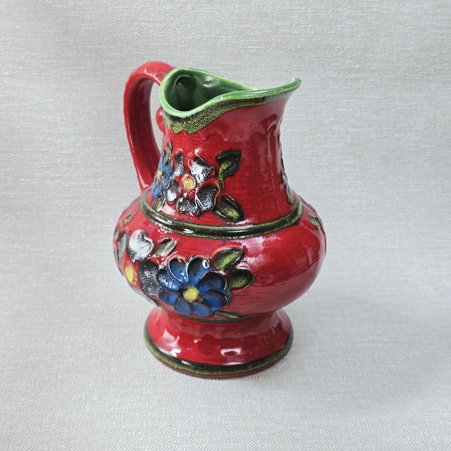 Roter Bay Keramik Krug mit reliefierten Blumen, West German Pottery 1960er, grün glasierte Innenfläche, Sammlerobjekt mit kleinem Chip am Bodenrand.