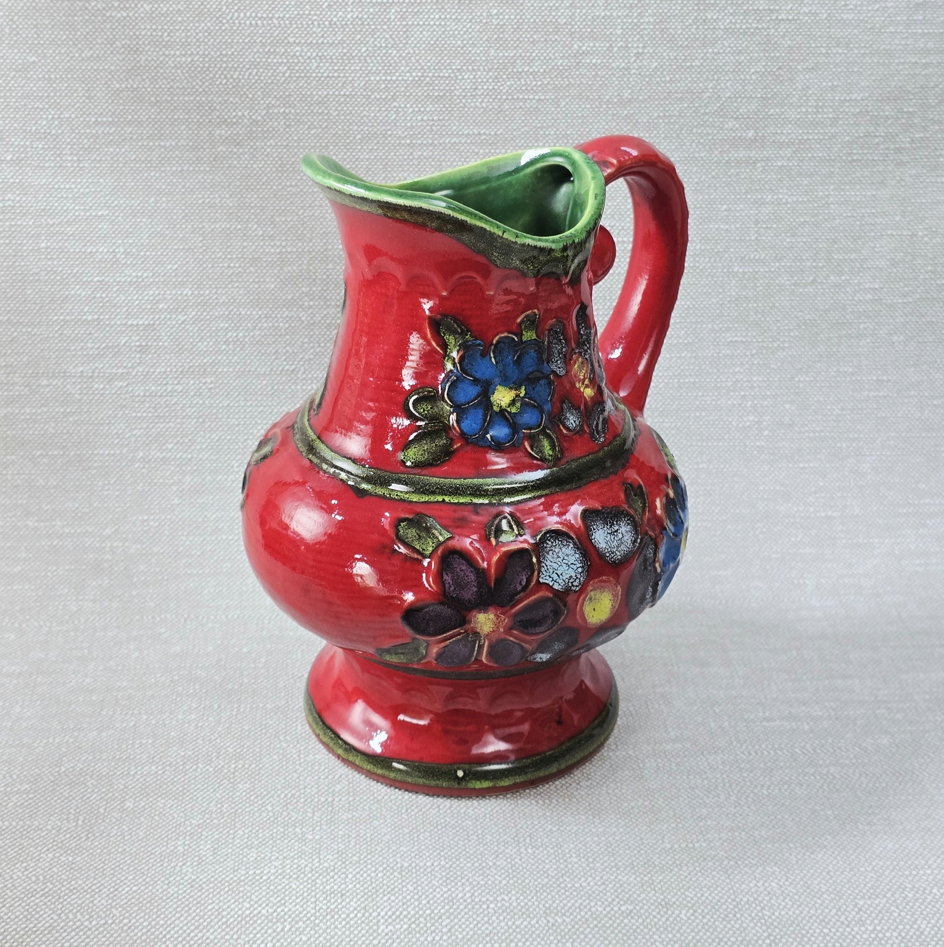 Roter Bay Keramik Krug mit reliefierten Blumen, West German Pottery 1960er, grün glasierte Innenfläche, Sammlerobjekt mit kleinem Chip am Bodenrand.