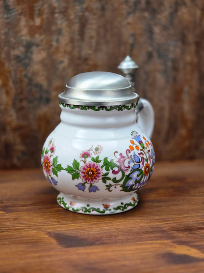 Ein klassisches Bierseidel aus Porzellan mit Zinndeckel, herausgegeben anlässlich des 25-jährigen Firmenjubiläums bei DATEV.