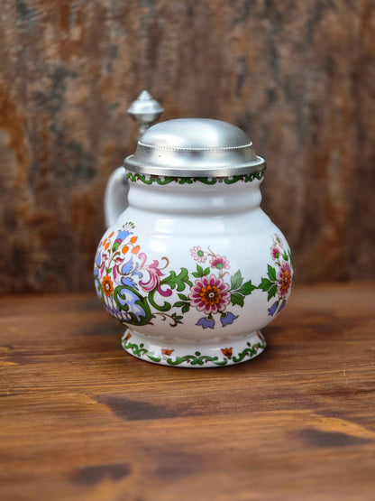 Ein klassisches Bierseidel aus Porzellan mit Zinndeckel, herausgegeben anlässlich des 25-jährigen Firmenjubiläums bei DATEV.