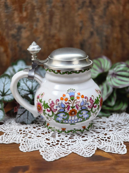 Ein klassisches Bierseidel aus Porzellan mit Zinndeckel, herausgegeben anlässlich des 25-jährigen Firmenjubiläums bei DATEV.