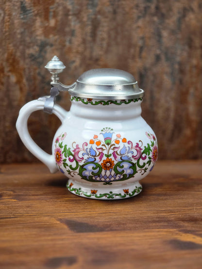 Ein klassisches Bierseidel aus Porzellan mit Zinndeckel, herausgegeben anlässlich des 25-jährigen Firmenjubiläums bei DATEV.