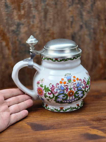 Ein klassisches Bierseidel aus Porzellan mit Zinndeckel, herausgegeben anlässlich des 25-jährigen Firmenjubiläums bei DATEV.