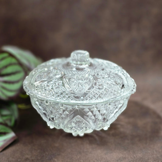 Vintage-Style Bonbonniere aus gepresstem Glas, KIG Malaysia. Schönes Relief, aber Randmacken vorhanden. Maße Ø13 cm, H9 cm, ca. 391 g. Vorsicht beim Reinigen.