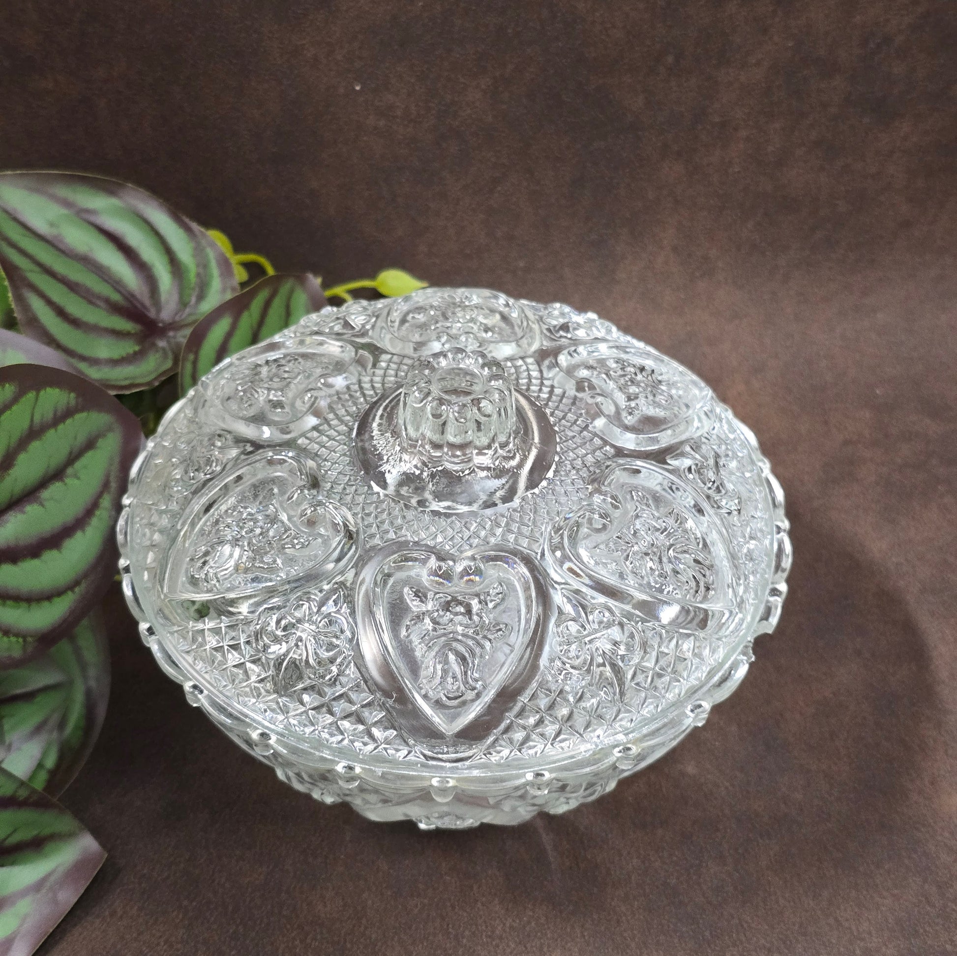 Vintage-Style Bonbonniere aus gepresstem Glas, KIG Malaysia. Schönes Relief, aber Randmacken vorhanden. Maße Ø13 cm, H9 cm, ca. 391 g. Vorsicht beim Reinigen.