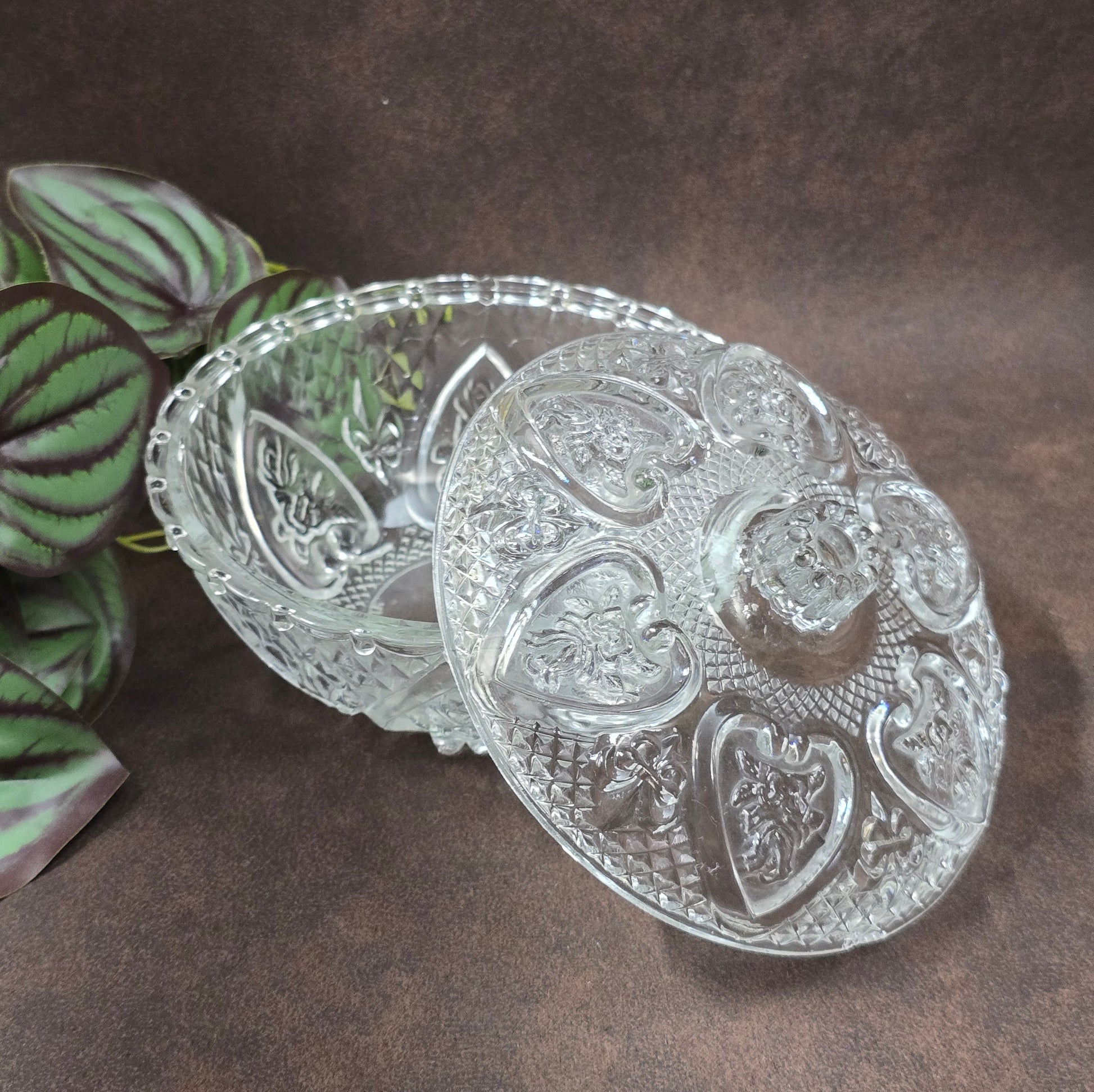 Vintage-Style Bonbonniere aus gepresstem Glas, KIG Malaysia. Schönes Relief, aber Randmacken vorhanden. Maße Ø13 cm, H9 cm, ca. 391 g. Vorsicht beim Reinigen.