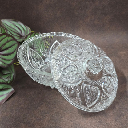Vintage-Style Bonbonniere aus gepresstem Glas, KIG Malaysia. Schönes Relief, aber Randmacken vorhanden. Maße Ø13 cm, H9 cm, ca. 391 g. Vorsicht beim Reinigen.